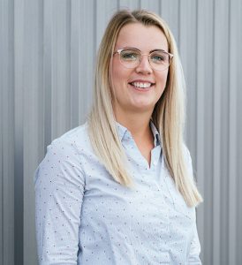 Sophia Plewa, Ansprechpartnerin der HNB Nordbleche GmbH, hellblaues Hemd, Brille und blonde Haare